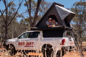 Adventure camping with a rooftop tent on a Red Dirt Rentals 4WD vehicle in the Australian outback.