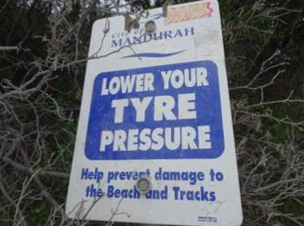 Sign advising to lower tire pressure to prevent beach and track damage.